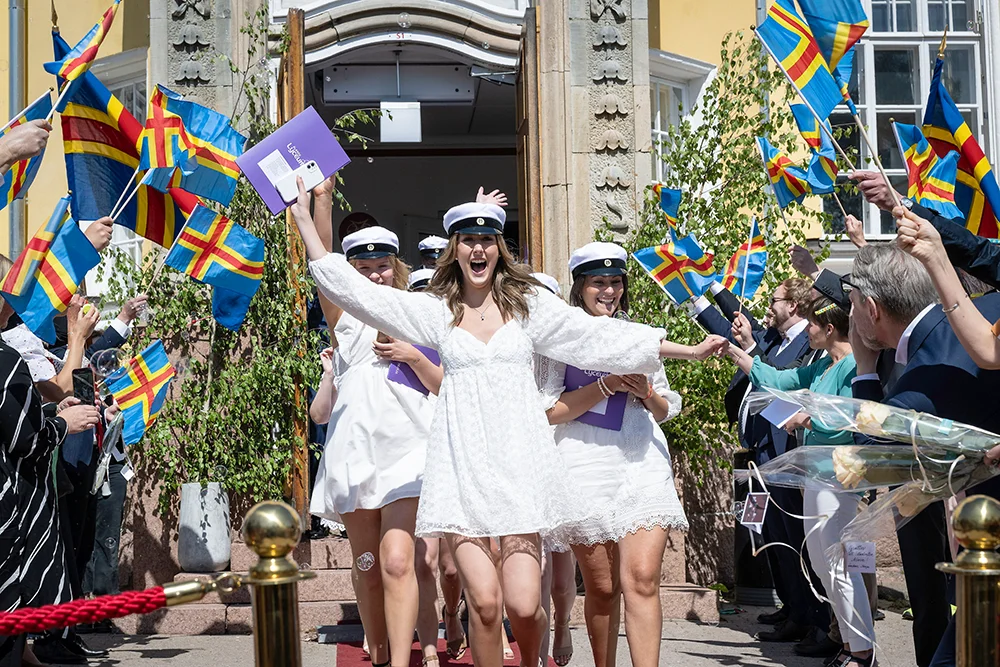 Studenter firar studenten på Åland med Ålands flaggor.