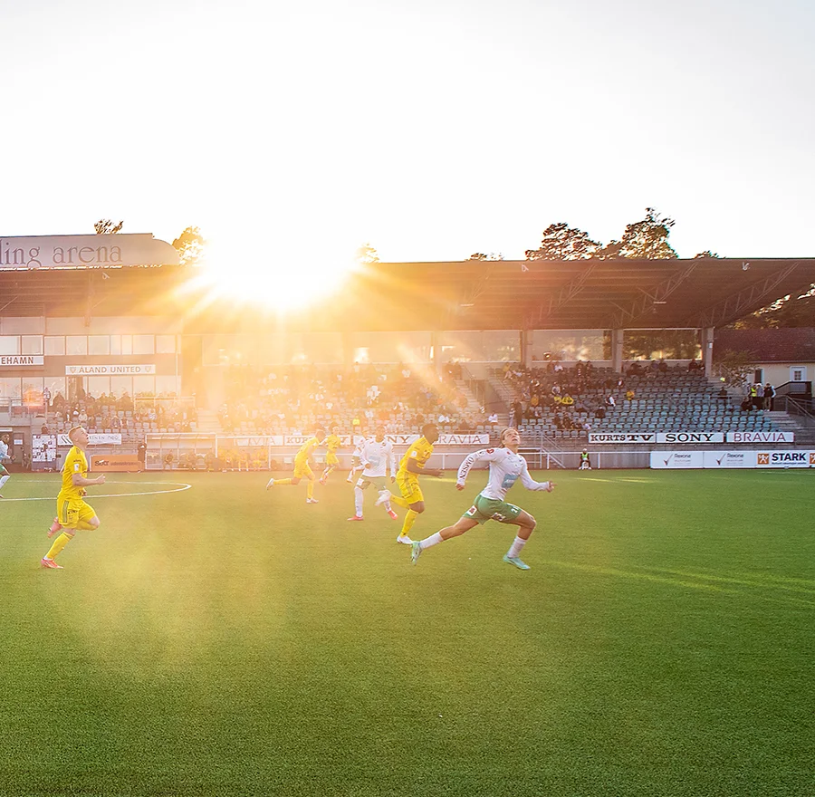Fotbollsmatch på Wiklöf Holding Arena i solnedgången.